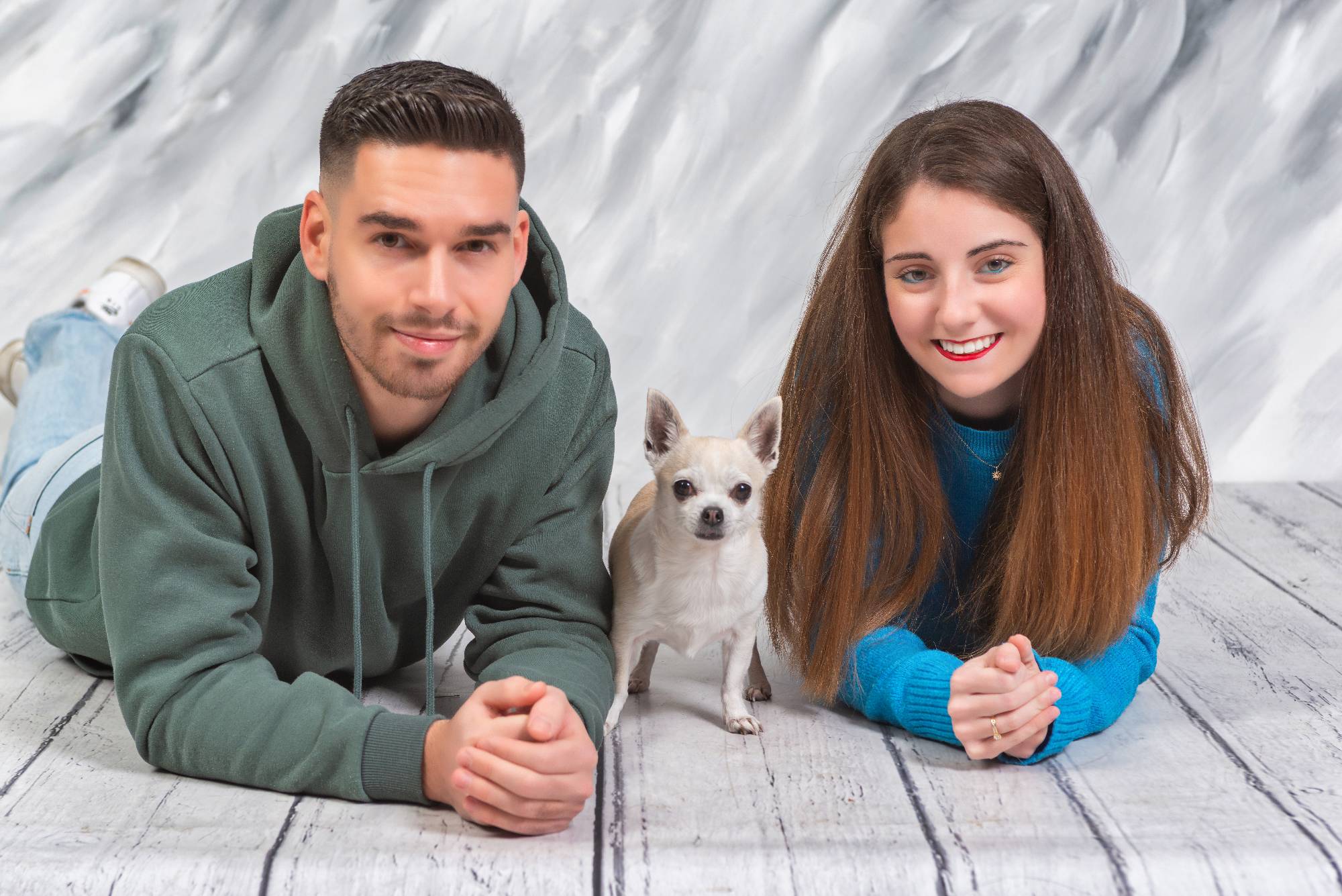 Pareja abrazando a su perro en sesión de fotos profesional